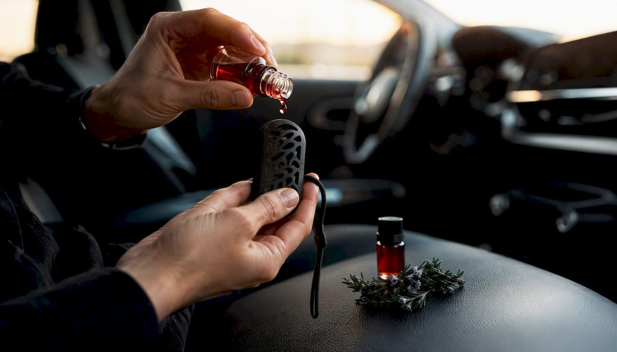 Hands applying botanical fragrance oil to car scent hanger